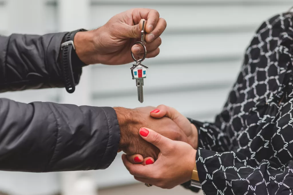 A man handing over his keys after selling his California house