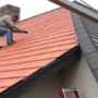 A skilled roofer works carefully on the terracotta roof.