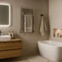 Modern beige bathroom with floating wooden vanity, LED mirror, heated towel rail, built-in shelving and a freestanding tub
